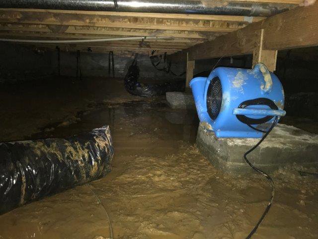 Muddy crawl space with standing water and drying equipment for water damage by Complete Restoration and Construction, LLC in Yakima, WA