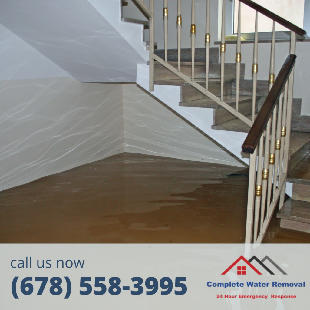 Muddy water damage on a staircase and floor, indicating a specialist job by Complete Water Removal and Restoration in Cumming, GA.