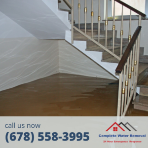 Muddy water damage on a staircase and floor, indicating a specialist job by Complete Water Removal and Restoration in Cumming, GA.