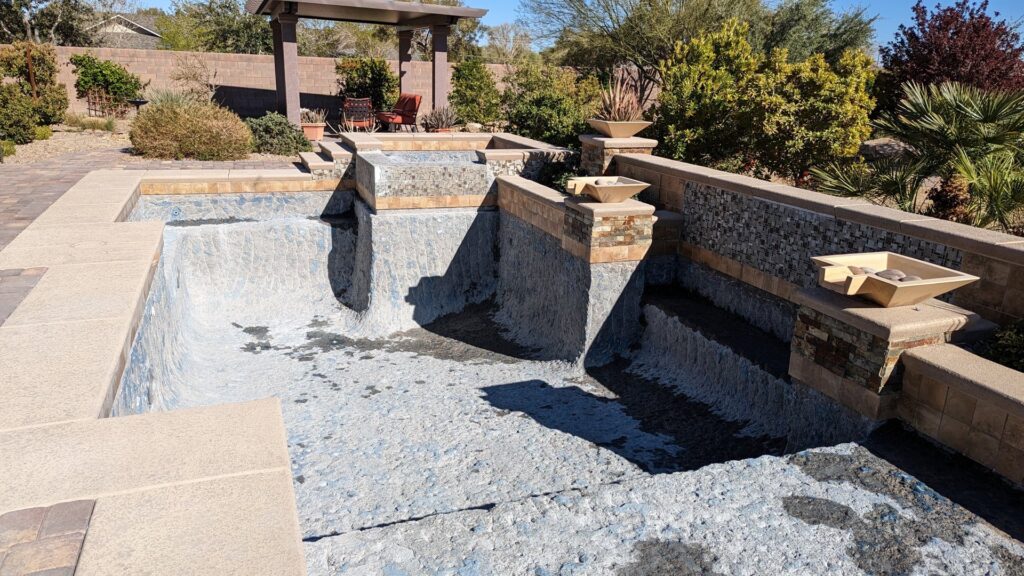 A multi-level pool under renovation, showing exposed aggregate finish and steps by Fix A Pool in Las Vegas, NV