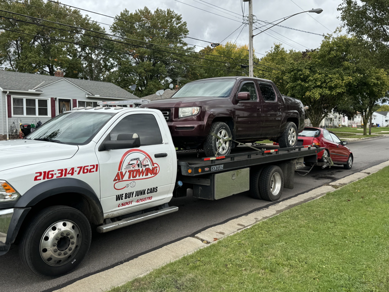 Av towing llc providing multi-vehicle towing service with a maroon pickup and a red car in Cleveland, OH.