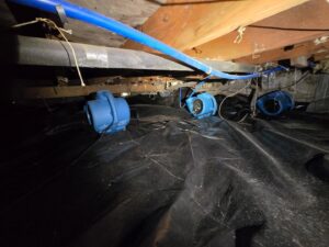 Multiple air movers drying a crawl space with a vapor barrier for Harbaugh Restoration in Vancouver, WA.