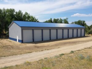 A large commercial building featuring multiple white rolling garage doors by Vertical Door Solutions in Sheridan, WY
