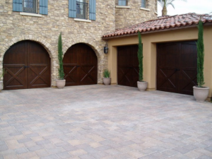 Multiple dark wood-style garage doors installed on a residential property by Pioneer Overhead Door in Las Vegas, NV