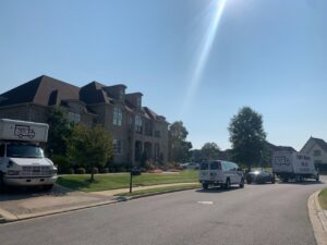 Multiple Family Movers 615 LLC trucks and a van parked on a residential street for a moving job in Goodlettsville, TN.