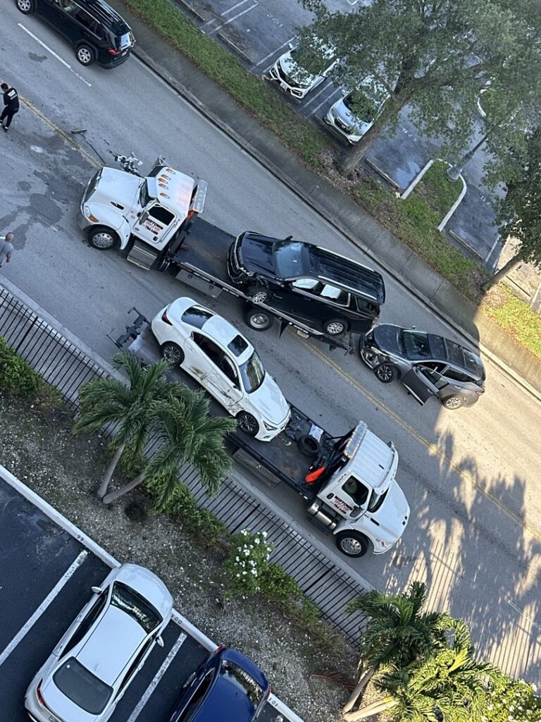 An aerial view showing multiple tow trucks from Rodicio Towing Services towing cars on a street in Hialeah, FL.