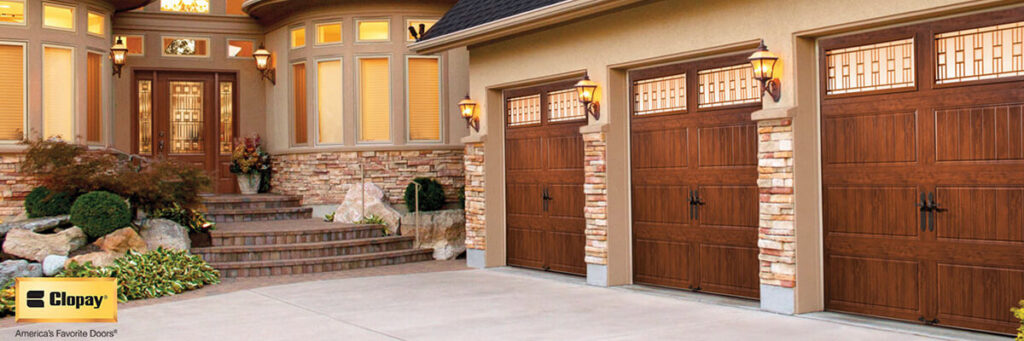 Three elegant wood-grain garage doors with decorative windows on a residential home by ALCAL Specialty Contracting Reno Sparks in Sparks, NV.