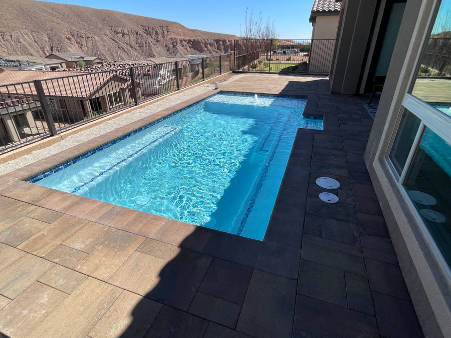 A narrow rectangular pool with a paver deck and mountain views, installed by Steve Breck Pools in Las Vegas, NV.