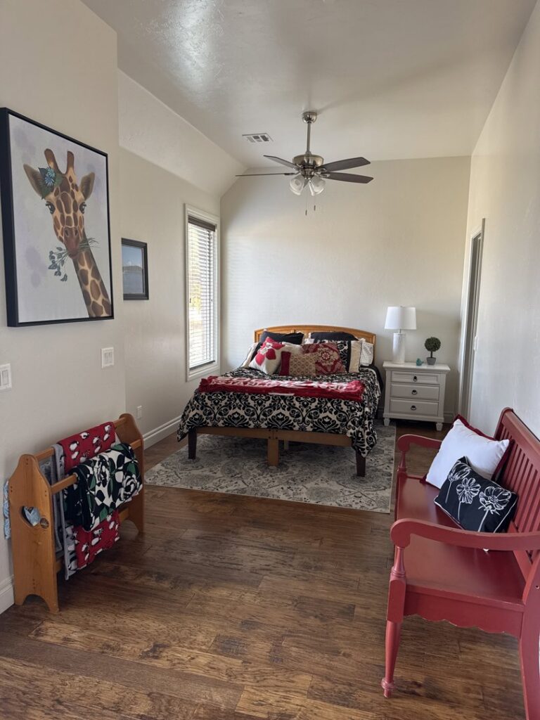 A neat and well-maintained bedroom with a comfortable bed and wooden floors, cleaned by Inspire Clean OKC in Oklahoma City, OK.