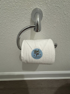 A neatly folded toilet paper roll with a 'Thank You' sticker, a thoughtful touch from Saari's Cleaning Services LLC in Jacksonville, FL.