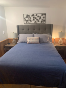 A neatly made bed in a clean bedroom, showcasing house cleaning services by Dust Devil Cleaning in Eugene, OR.