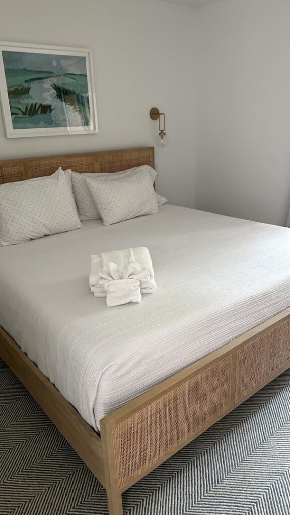 A neatly made bed with fresh, folded towels, showcasing the meticulous service of Vidal Cleaning in North Charleston, SC.