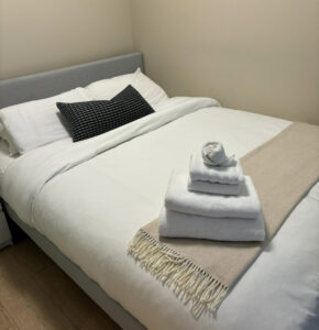 A neatly made bed with fresh, folded towels, showcasing Trust-Clean's attention to detail in Green Bay, WI.