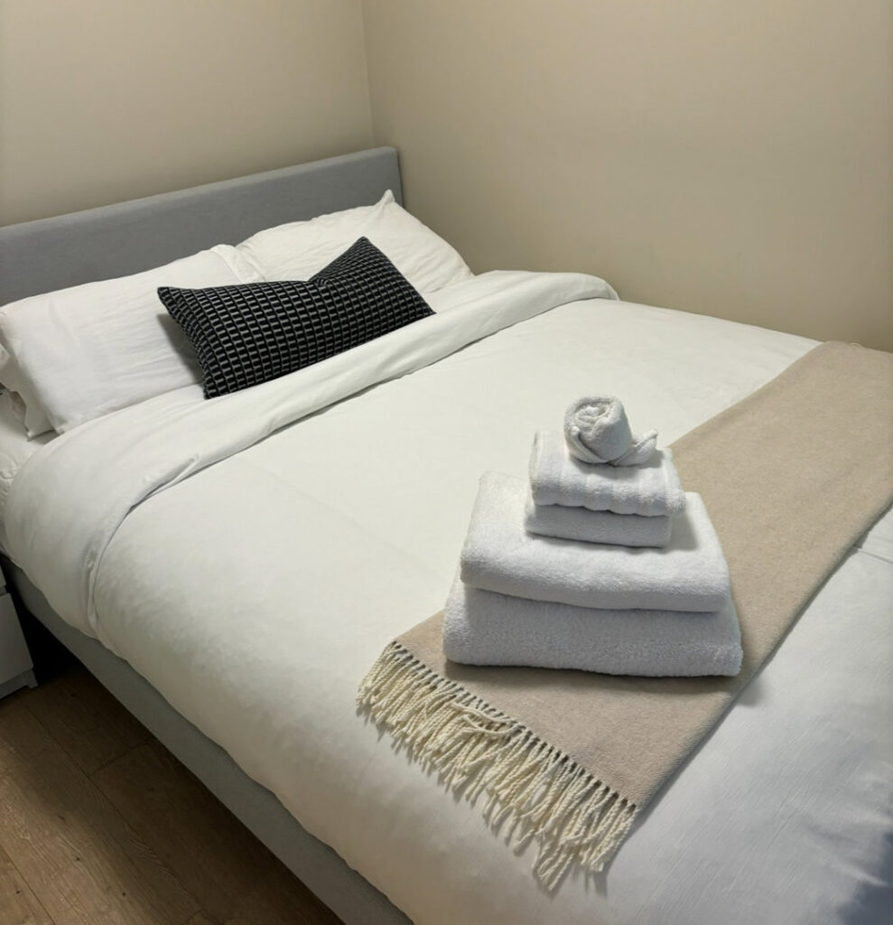 A neatly made bed with fresh, folded towels, showcasing Trust-Clean's attention to detail in Green Bay, WI.