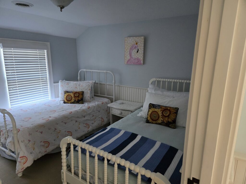 Two beds neatly made in a clean bedroom, showcasing tidying services by Solange D Kleaner in New Bedford, MA.