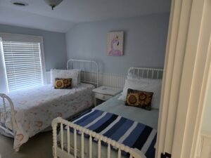 Two beds neatly made in a clean bedroom, showcasing tidying services by Solange D Kleaner in New Bedford, MA.