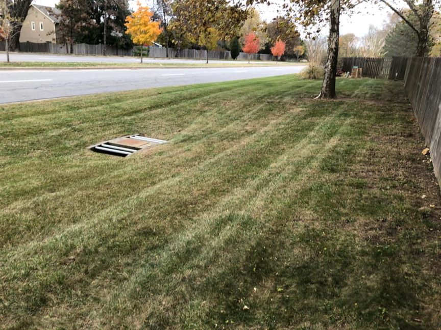 A neatly mowed roadside lawn with clean stripes, demonstrating quality service from Kemple Lawn Care in Lawrence, KS.