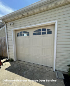 A new beige garage door with arched windows installed by Delaware Express Garage Door Service in Wilmington, DE