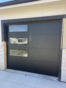 A newly installed black modern garage door by Garage Door Services, Inc. in Omaha, NE.