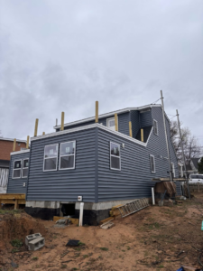 New blue siding installation on a house by High Quality Exteriors in Rockville, MD.