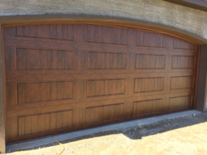 A newly installed brown garage door with an arched top by Alpine Overhead Garage Door Service in Layton, UT.