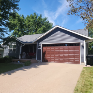 A newly installed brown garage door on a residential home by 74 Garage Door Company in Lake Park, FL