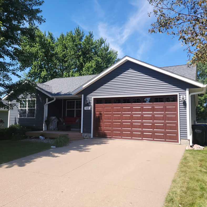 A newly installed brown garage door on a residential home by 74 Garage Door Company in Lake Park, FL