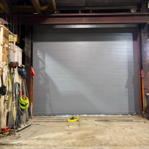 A newly installed commercial roll-up garage door inside a workshop by Alaska Door in Wasilla, AK.