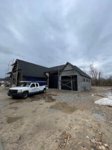 A ProLift Garage Doors of Canyon County truck at a new construction site with recently installed black garage doors in Nampa, ID.