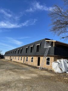 New construction building with house wrap installed, ready for siding by JHV Roofing in Scranton, PA.