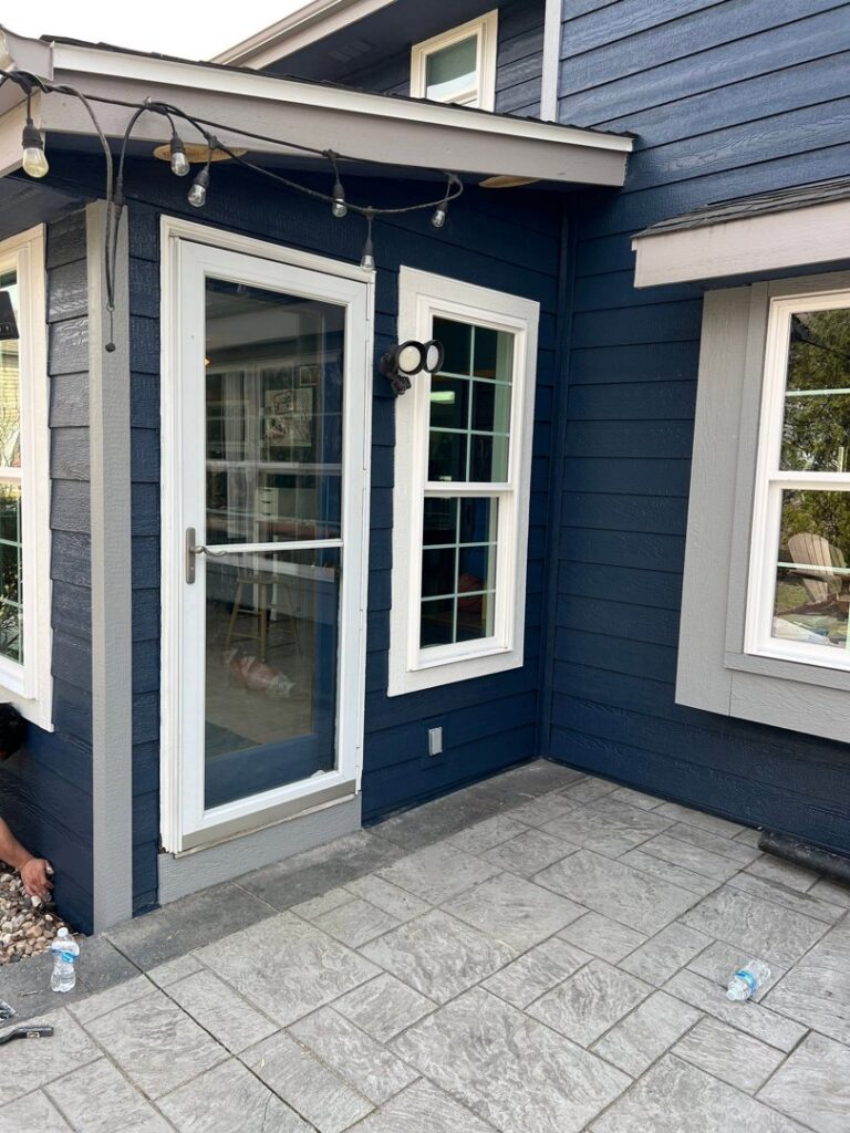 A residential home featuring newly installed dark blue siding and white trim by Wisconsin Exteriors in Kaukauna, WI.