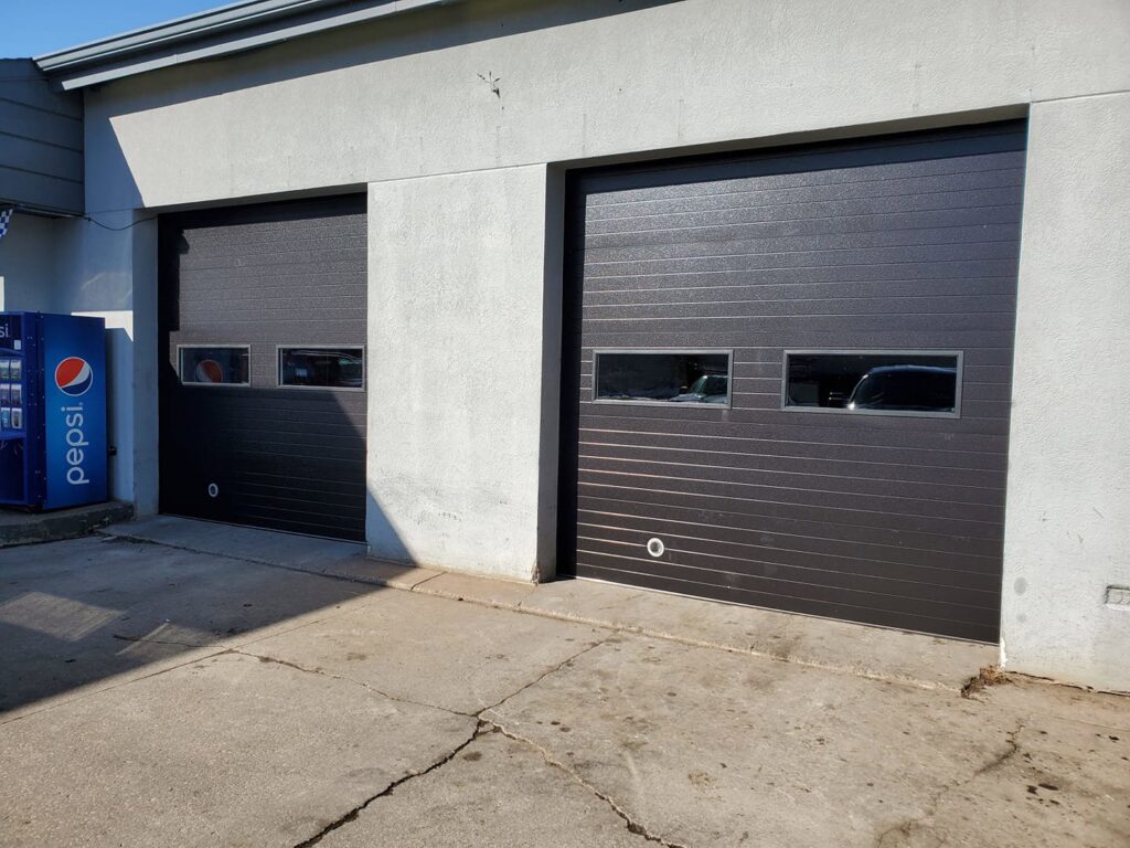 Newly installed dark brown garage doors on a residential home by 74 Garage Door Company in Lake Park, FL