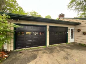 Newly installed dark brown garage doors with windows by Precision Garage Door Service of NC in Morrisville, NC.