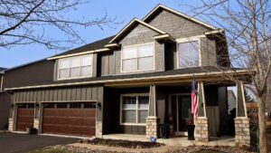 A newly sided house featuring dark brown siding and decorative stone accents, completed by Archcraft Exteriors in South Saint Paul, MN.