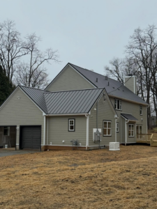 A newly sided house featuring light green vinyl siding and a dark metal roof by CRD Builders in Hamilton Township, NJ.
