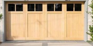 A newly installed modern wooden garage door with vertical windows on a house wrapped in Tyvek by NV Pro Garage Doors in Las Vegas, NV.