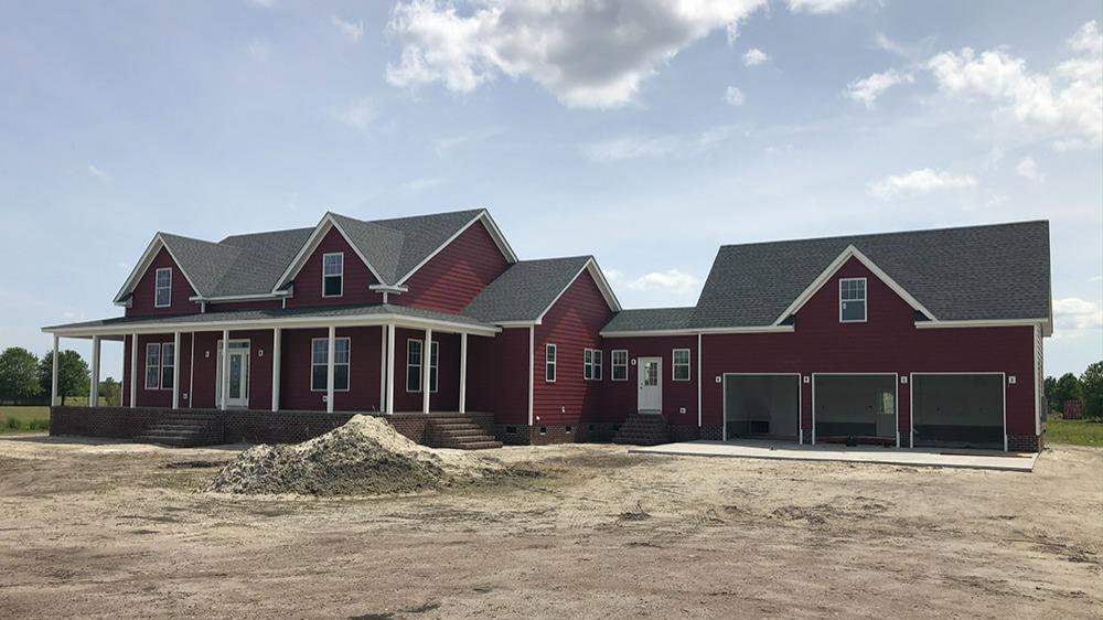 A newly constructed house featuring vibrant red siding installed by Cordell Exteriors Inc in Chesapeake, VA