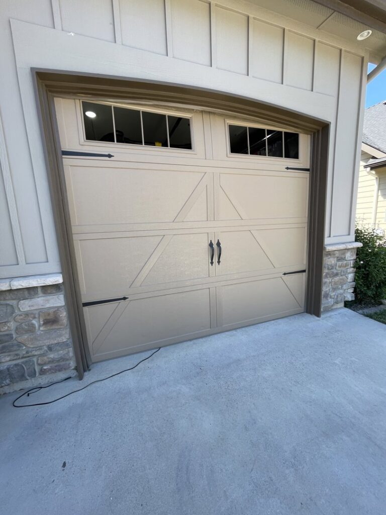 A newly installed residential garage door with decorative hardware, completed by ProLift Garage Doors of Canyon County in Nampa, ID.