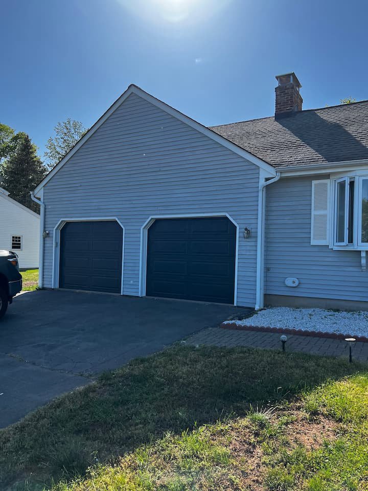 A house exterior showcasing newly installed light gray siding by Coastal Construction Group LLC in Cheshire, CT.