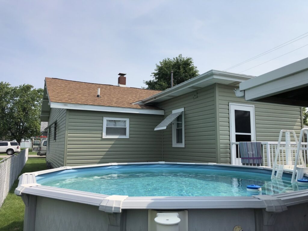 A house with newly installed light green siding completed by Freeman Exteriors in Danville, IL.