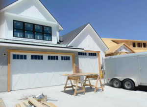 New white garage doors installed on a construction site by Next Level Garage Doors in Locust Grove, GA.