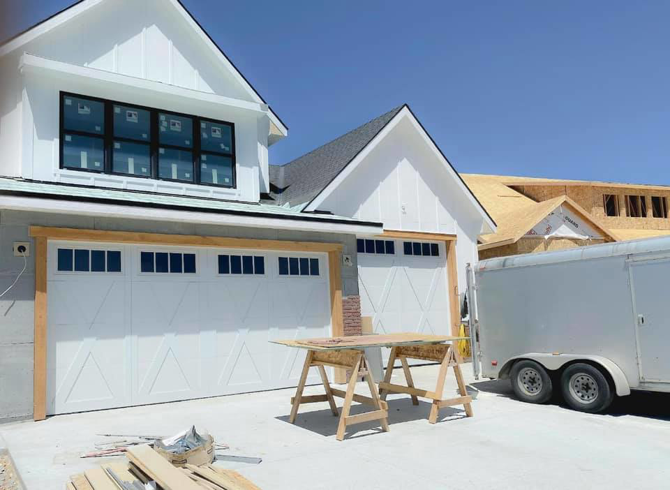 New white garage doors installed on a construction site by Next Level Garage Doors in Locust Grove, GA.