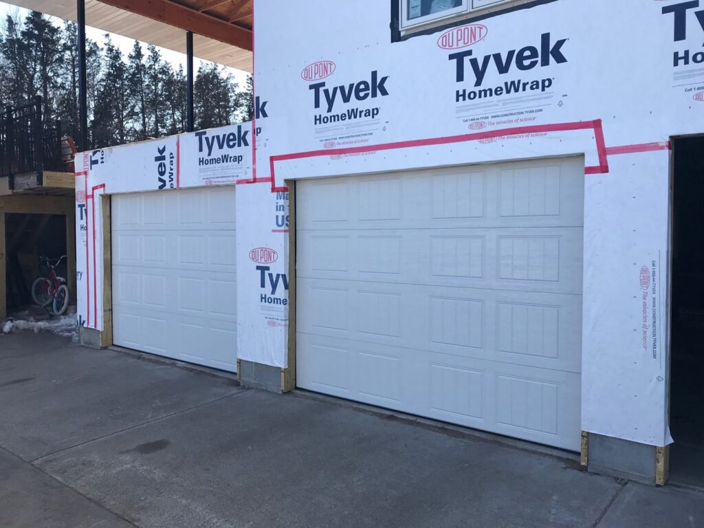 New white panel garage doors installed on a residential construction project by Elite Door in Winchester, CA.