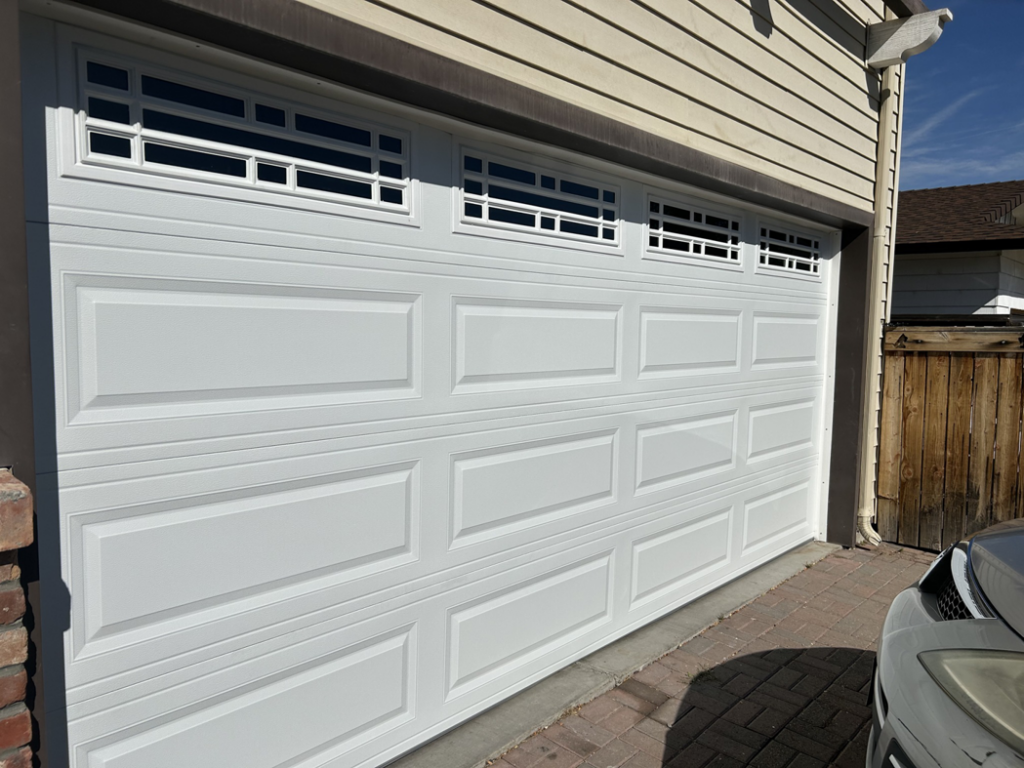 A newly installed white paneled garage door with decorative windows by Summit-Overhead-Door in Sparks, NV.