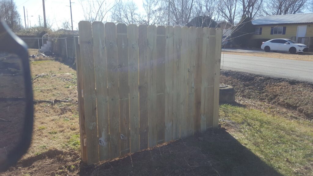 A newly installed wooden privacy fence in a residential backyard by Full Throttle landscapes and lawn care in Port Orchard, WA.