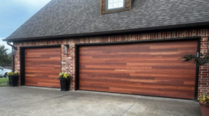 Two newly installed wooden-look garage doors on a brick home by GRIT Garage Doors in Alma, AR