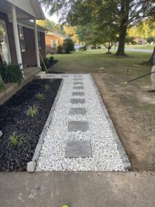 A newly installed gravel pathway with stepping stones and an adjacent mulched garden bed by The Otherside Lawn Solutions in Ankeny, IA.
