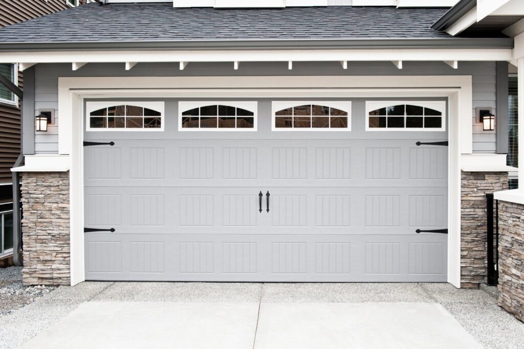 A newly installed modern grey garage door with windows on a residential home by Garage Door Medics in Boise, ID.