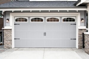 A newly installed modern grey garage door with windows on a residential home by Garage Door Medics in Boise, ID.