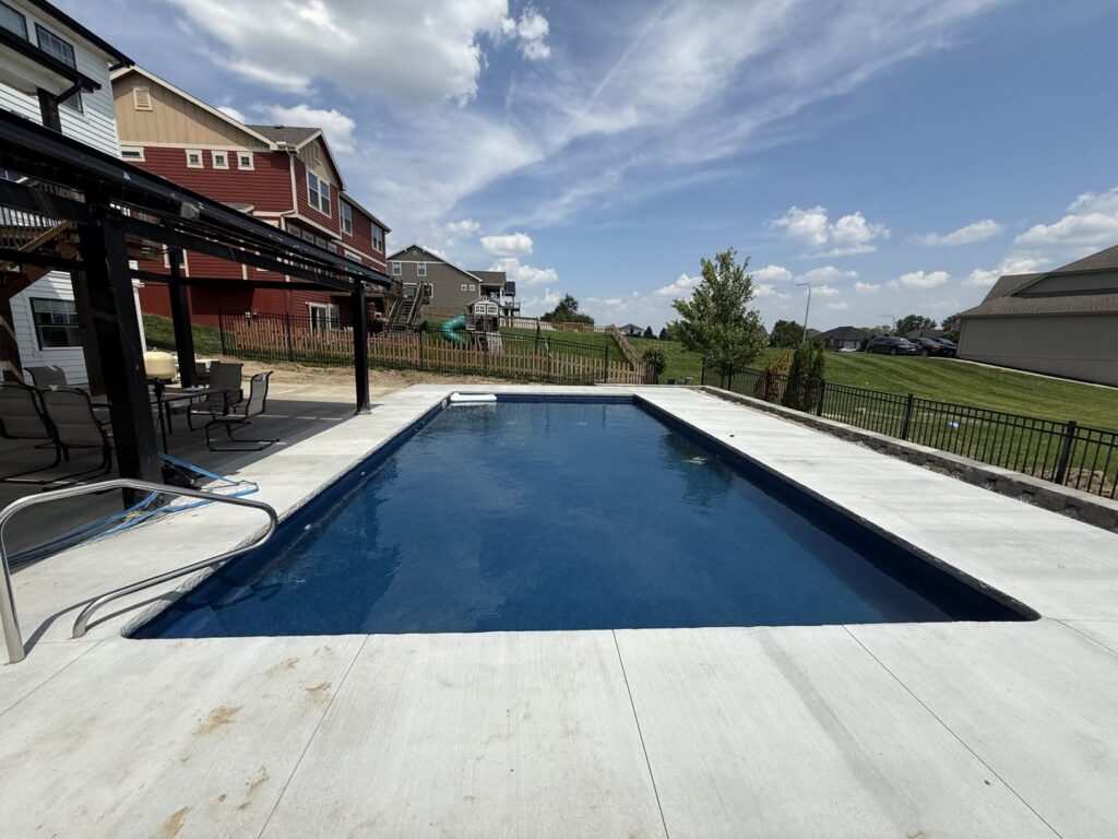 A newly installed rectangular swimming pool with a spacious concrete patio, completed by Acapulco Pool and Spa LLC in Los Angeles, CA